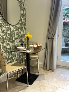 einen Tisch mit einer Vase aus Blumen und einem Spiegel in der Unterkunft The Courtyard, Manstone House in Kent