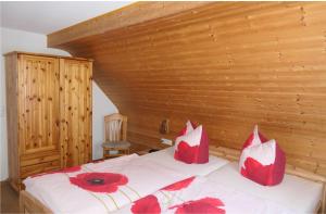 um quarto com uma cama com almofadas vermelhas em 4 Sterne Ferienwohnung Sommerberg em Rohrbach