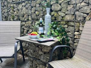 einen Tisch mit einer Flasche Wein und einer Schale Obst in der Unterkunft The Courtyard, Manstone House in Kent