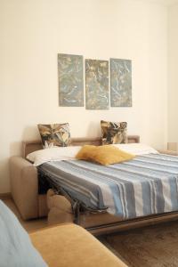 2 camas en una habitación con pinturas en la pared en Casa Pierina, en Santa Marinella