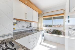 eine Küche mit einem Waschbecken und einem Fenster in der Unterkunft Shinning View Apartment in Armação de Pêra