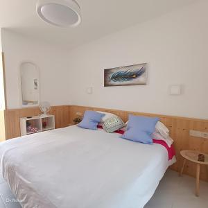 un letto bianco con cuscini blu e un telefono sopra di Apartment El Barco - Las Casas de Aron a Caleta De Fuste