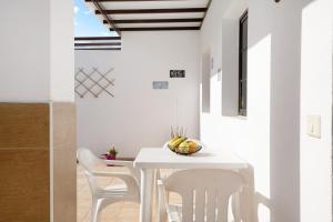 un comedor blanco con una mesa y sillas blancas en Casa Candido 2 en Playa Honda