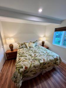卡內奧赫的住宿－Cozy Custom Vacation Home，一间卧室配有一张床,两盏台灯放在两张桌子上