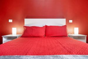 Dormitorio rojo con cama con sábanas y almohadas rojas en Casa Candido 2 en Playa Honda