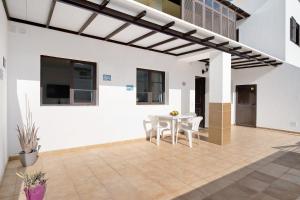 翁達海灘的住宿－Casa Candido 2，白色的房子,配有白色的桌子和椅子