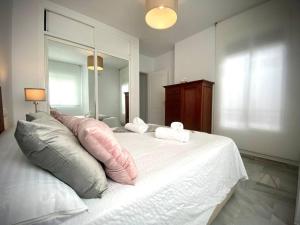- une chambre avec un grand lit et des oreillers dans l'établissement MyChoice Ático de Luna by Bossh! Apartments, à Rota