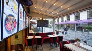 un restaurant avec des tables et des chaises et une grande fenêtre dans l'établissement Fidan City Hotel, à Istanbul