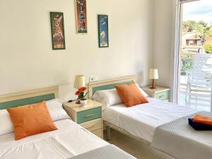 a bedroom with two beds and a balcony at APARTBEACH LARIMAR MUY LUMINOSO y CLIMATIZADO in Salou