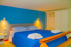 - une chambre bleue avec un lit et des serviettes dans l'établissement MAISON SAN MARTINO, à Naples