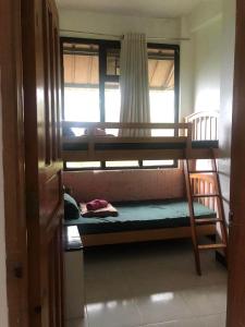 een kamer met 2 stapelbedden en een raam bij GH Apartelles in Baguio