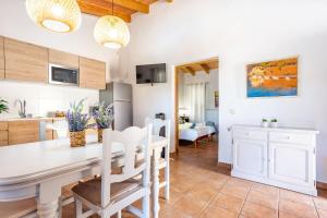 a kitchen and dining room with a white table and chairs at Son Sec mit Pool und Wifi in Cala Santanyi