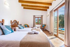 a bedroom with two beds and a view of the pool at Son Sec mit Pool und Wifi in Cala Santanyi