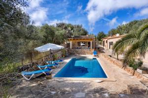 an outdoor swimming pool with chairs and a house at Son Sec mit Pool und Wifi in Cala Santanyi
