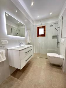 a bathroom with a sink and a toilet and a mirror at Yiouli Holiday Home in Acharavi