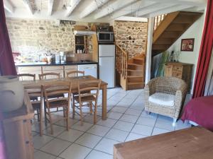 - une cuisine et une salle à manger avec une table et des chaises dans l'établissement Le Moulin de la Fortie, Gîtes, à Viscomtat