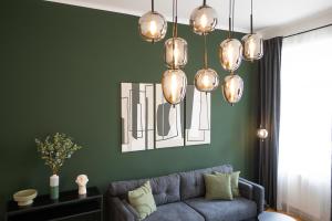 a living room with a blue couch and a chandelier at Brand-new apartment with a breathtaking design located right near Belvedere Castle, 15 minutes from city centre in Vienna