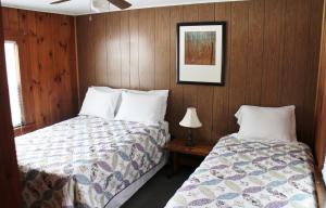 a bedroom with two beds and a picture on the wall at Pine Valley Cabins in Thornton