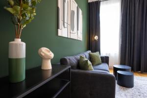 a living room with a blue couch and green walls at Brand-new apartment with a breathtaking design located right near Belvedere Castle, 15 minutes from city centre in Vienna