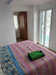 Una cama con una bolsa verde encima. en affittacamere nuova Vandiris, en Manarola