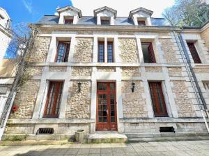 een oud stenen gebouw met een rode deur bij Le OSLO, à 50m de la gare TV connecté+Fibre in Poitiers