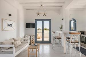 eine Küche und ein Wohnzimmer mit einem Tisch und Stühlen in der Unterkunft Pebble Summer House in Kampos Paros