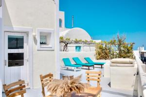 d'un balcon avec des chaises bleues et une table. dans l'établissement Dawn Suites Santorini, à Vourvoúlos