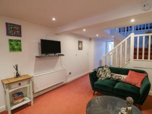 a living room with a green couch and a tv at 83 Upper John Street in Wexford
