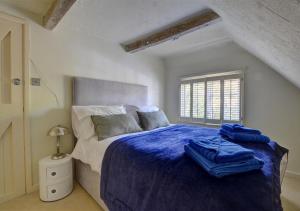 a bedroom with a bed with blue sheets and a window at 3 Stable Mews in Royal Tunbridge Wells +5 photos