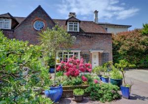 dom z kupą roślin przed nim w obiekcie 3 Stable Mews w mieście Royal Tunbridge Wells
