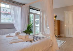 a bedroom with a bed with white sheets and a window at Beachside Hideaway in Broadstairs