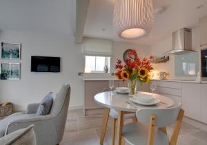 a kitchen and a table with a vase of flowers on it at Beech Cottage at Fir House in Cranbrook