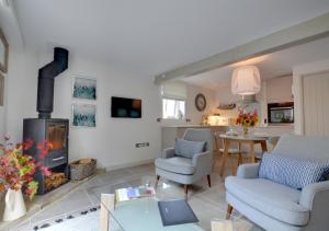 a living room with a fireplace and a table at Beech Cottage at Fir House in Cranbrook