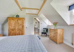 1 dormitorio con cama y tocador de madera en Bewl Water View en Ticehurst