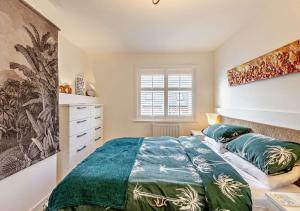 a bedroom with a bed and a painting on the wall at Beachtown Cottage in Broadstairs