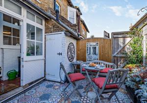 a patio with a table and chairs and a fence at Beachtown Cottage in Broadstairs