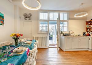 a dining room with a table and a kitchen at Beachtown Cottage in Broadstairs