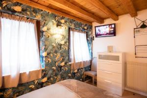 1 dormitorio con 1 cama y TV en la pared en Kate's Home en Udine