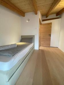 a bedroom with a bed and a wooden door at API Tenna Apartments Edera 3 in Tenna 