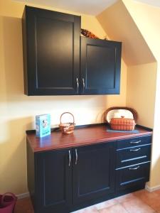 a kitchen with black cabinets and a wooden counter top at Ferienwohnung Varmissen in Dransfeld
