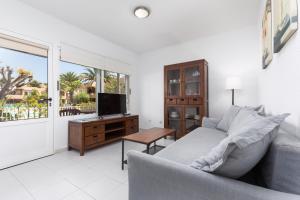 un soggiorno con divano e TV di Home2Book Charming Sun & Dunes Apartment a Corralejo