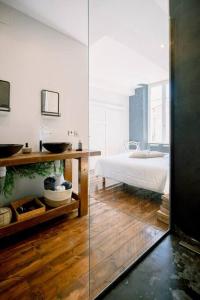 1 dormitorio con cama, lavabo y espejo en L'Oasis - Charme et confort au centre-ville en Albi