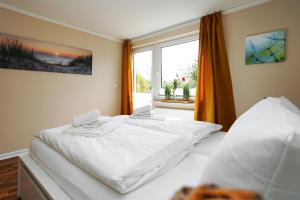 Un dormitorio con dos camas y una ventana. en Silwai EG, en Tinnum