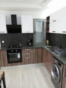 uma cozinha com um lavatório e uma máquina de lavar louça em Résidence Inès Djerba Appartements VIP em Houmt Souk