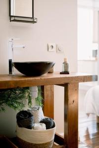 La salle de bains est pourvue d'une table en bois et d'un lavabo. dans l'établissement L'Oasis - Charme et confort au centre-ville, à Albi