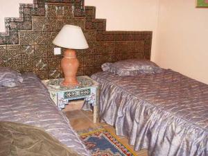 A bed or beds in a room at HOTEL KERDOUS