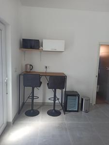 a desk with two chairs in a room at Venite Rooms in Velika
