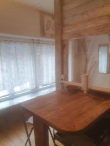 een houten tafel in een kamer met ramen bij bienvenue chez les choup;s le p;tit laponie in La Bourboule
