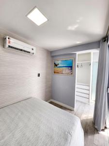 a bedroom with a bed and a air conditioner at Cobertura em Ondina in Salvador