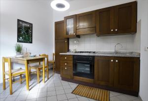 una cocina con armarios de madera y una mesa con fregadero en U Ciousu by Ligurian Life APPARTAMENTI IN AGRITURISMO, en Vallebona